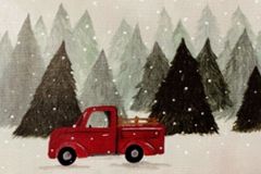 A red truck driving in front of a pine forest with light snow falling.