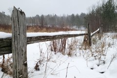 A picture of an old wooden fence in a snow covered field